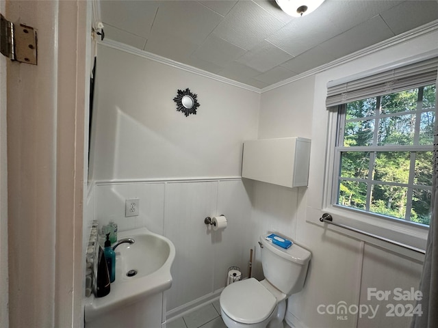 bathroom featuring tile patterned floors, crown molding, toilet, and sink