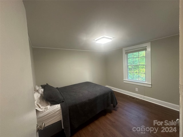 bedroom with dark hardwood / wood-style flooring