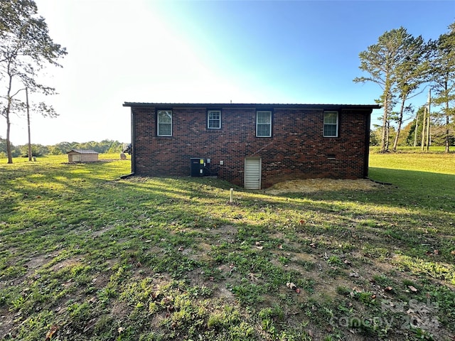 view of property exterior featuring a storage unit, a lawn, and central AC