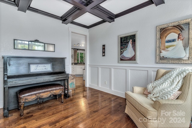 living area with coffered ceiling, beamed ceiling, crown molding, and dark wood-type flooring