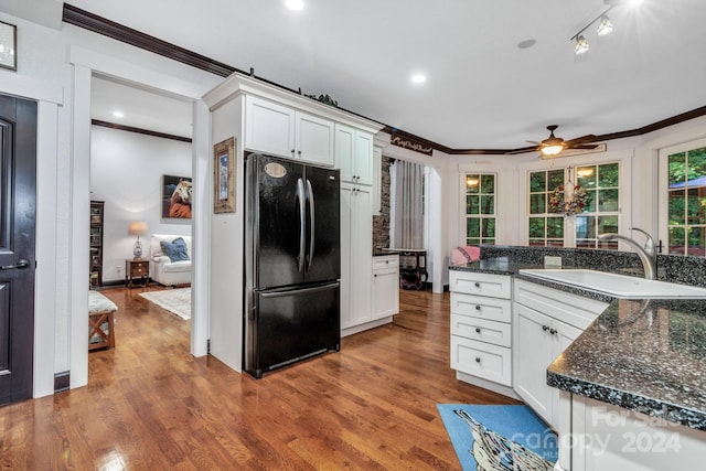 kitchen featuring white cabinets, sink, dark wood-type flooring, and black refrigerator