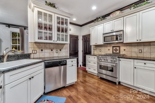 kitchen with crown molding, appliances with stainless steel finishes, and white cabinets