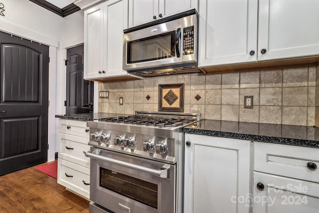 kitchen with ornamental molding, dark hardwood / wood-style floors, stainless steel appliances, and white cabinets