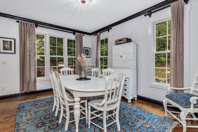 dining area featuring ornamental molding and dark wood-type flooring