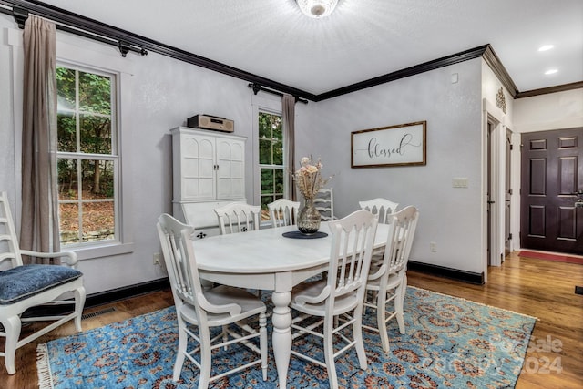 dining room with ornamental molding and hardwood / wood-style flooring