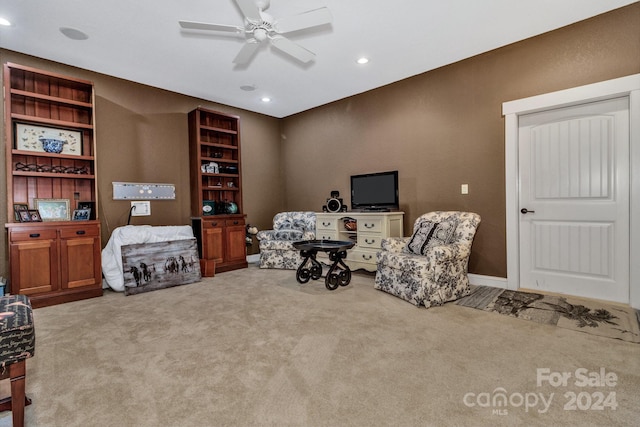 living area featuring carpet floors, built in features, and ceiling fan