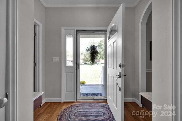 entryway featuring wood-type flooring and ornamental molding