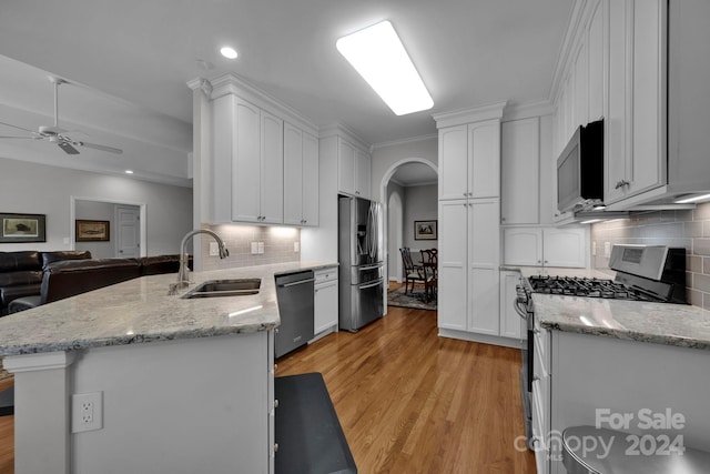 kitchen with stainless steel appliances, light hardwood / wood-style floors, white cabinets, and sink