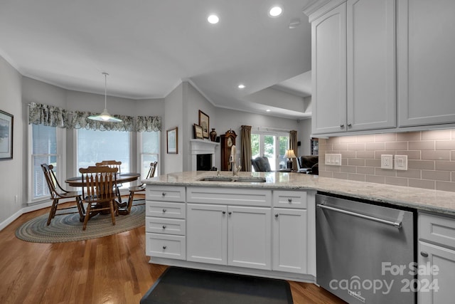 kitchen featuring light hardwood / wood-style floors, sink, dishwasher, kitchen peninsula, and white cabinets