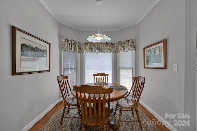 dining area featuring wood-type flooring and ornamental molding