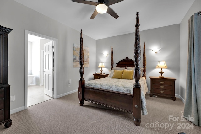 bedroom with ceiling fan, light colored carpet, and ensuite bath