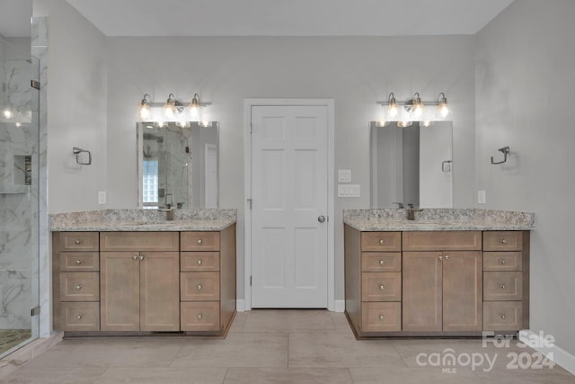 bathroom featuring tile patterned floors, a shower with shower door, and vanity