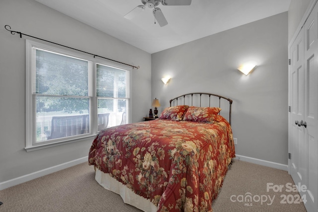 bedroom featuring light carpet, multiple windows, and ceiling fan