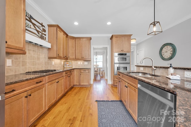 kitchen featuring pendant lighting, stainless steel appliances, sink, and dark stone countertops