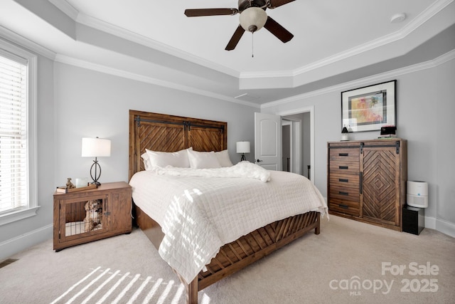 carpeted bedroom with crown molding, ceiling fan, and a tray ceiling