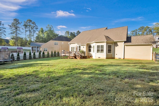 back of property with a wooden deck and a yard