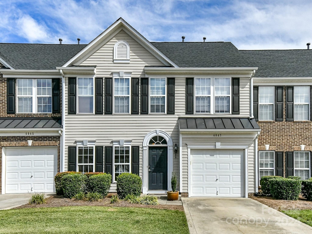 multi unit property featuring a front yard and a garage