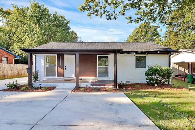 view of front of home featuring covered porch and a front lawn