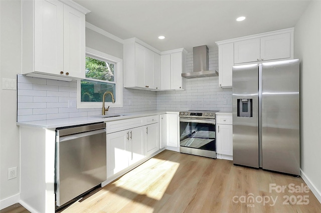 kitchen featuring stainless steel appliances, sink, white cabinets, and wall chimney exhaust hood