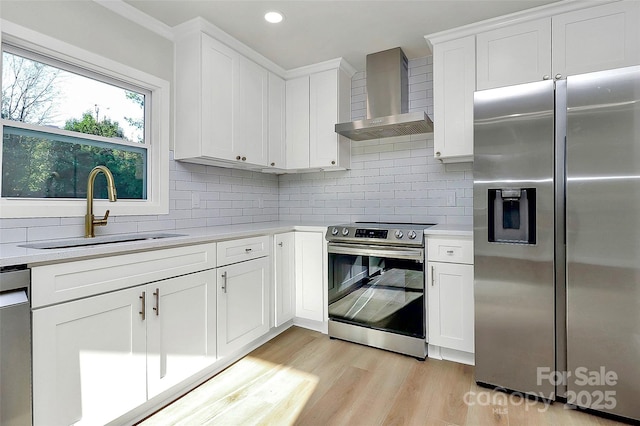 kitchen featuring sink, white cabinetry, stainless steel appliances, decorative backsplash, and wall chimney exhaust hood