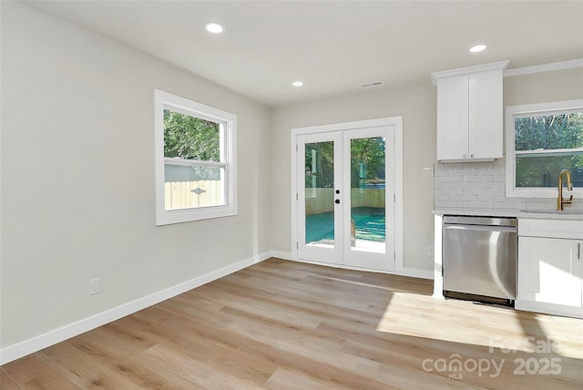 entryway with sink, light wood-type flooring, and french doors