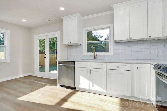 kitchen with white cabinetry, sink, decorative backsplash, and stainless steel appliances