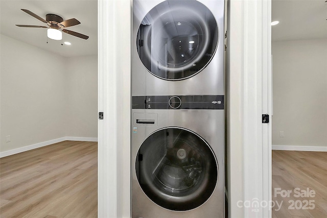 laundry area featuring stacked washer / drying machine, ceiling fan, and light wood-type flooring