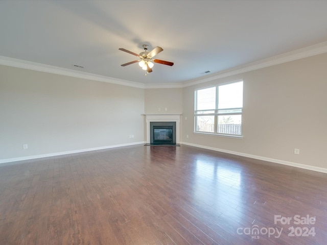 unfurnished living room with crown molding, dark wood-type flooring, and ceiling fan