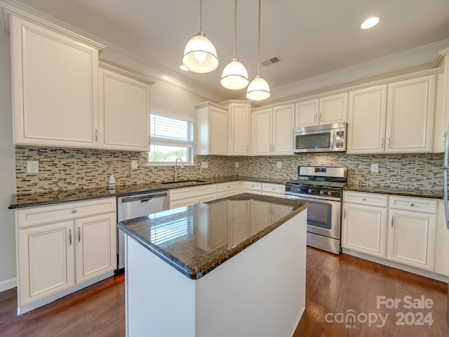 kitchen featuring sink, a kitchen island, appliances with stainless steel finishes, and dark hardwood / wood-style floors