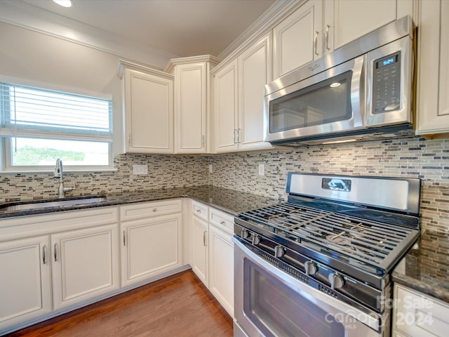 kitchen featuring sink, appliances with stainless steel finishes, white cabinets, and tasteful backsplash