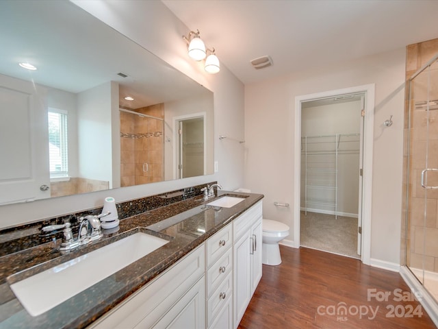 bathroom featuring vanity, toilet, hardwood / wood-style flooring, and walk in shower