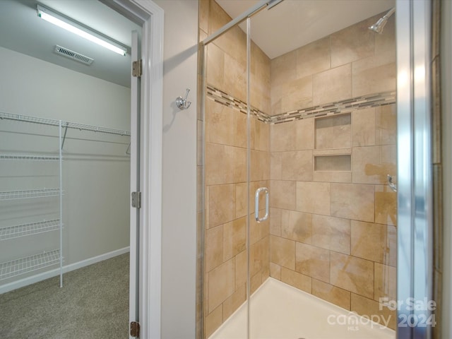 bathroom with a shower with door