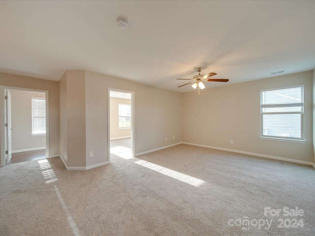 carpeted spare room featuring ceiling fan