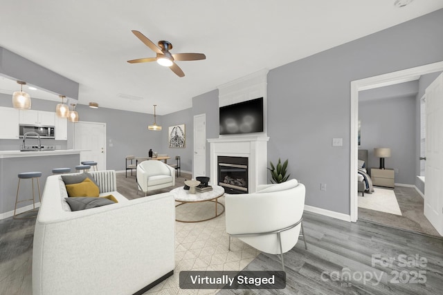 living room featuring hardwood / wood-style floors and ceiling fan