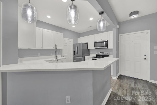 kitchen with sink, hanging light fixtures, appliances with stainless steel finishes, kitchen peninsula, and white cabinets