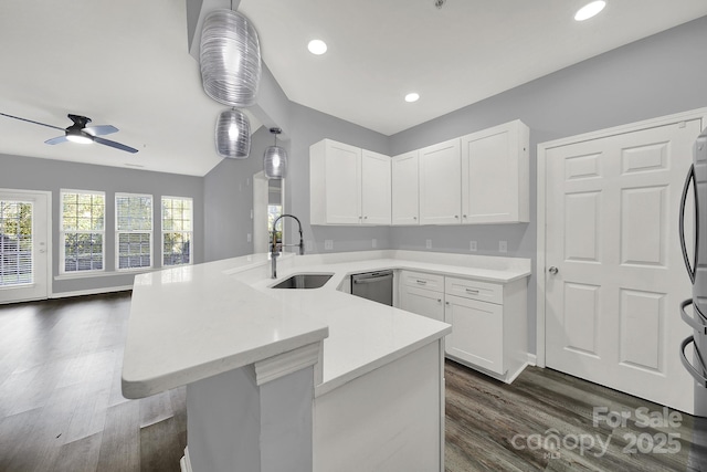 kitchen featuring sink, hanging light fixtures, white cabinets, dark hardwood / wood-style flooring, and kitchen peninsula