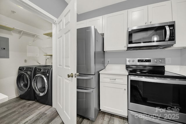 kitchen featuring separate washer and dryer, electric panel, white cabinets, and appliances with stainless steel finishes