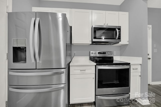 kitchen featuring white cabinetry, dark wood-type flooring, and appliances with stainless steel finishes