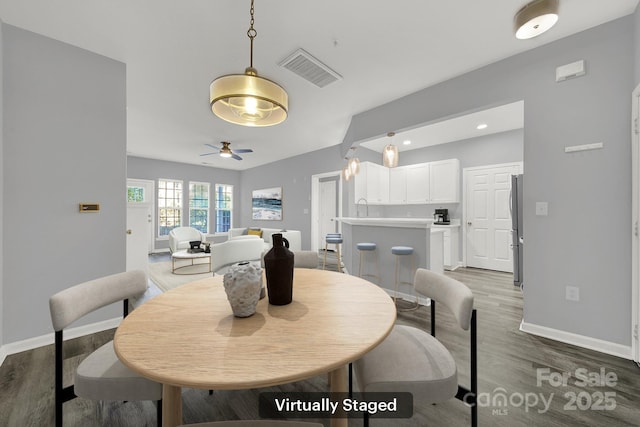 dining space featuring sink, hardwood / wood-style flooring, and ceiling fan