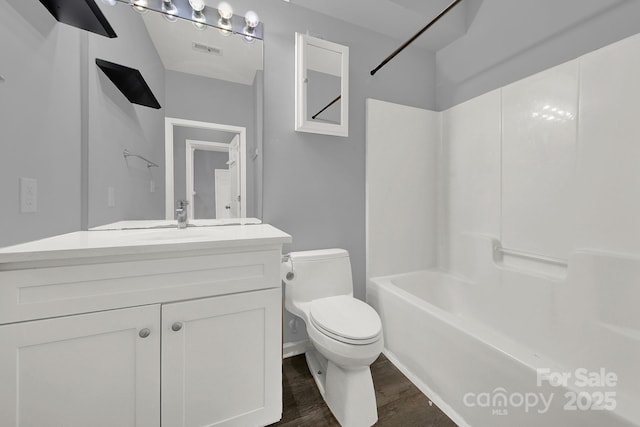 full bathroom with vanity, hardwood / wood-style floors, shower / bathtub combination, and toilet