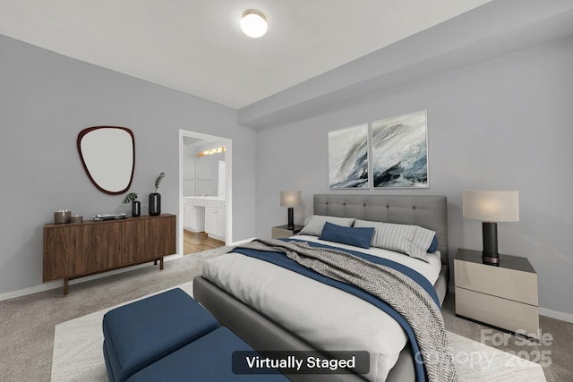 bedroom featuring light colored carpet and ensuite bathroom