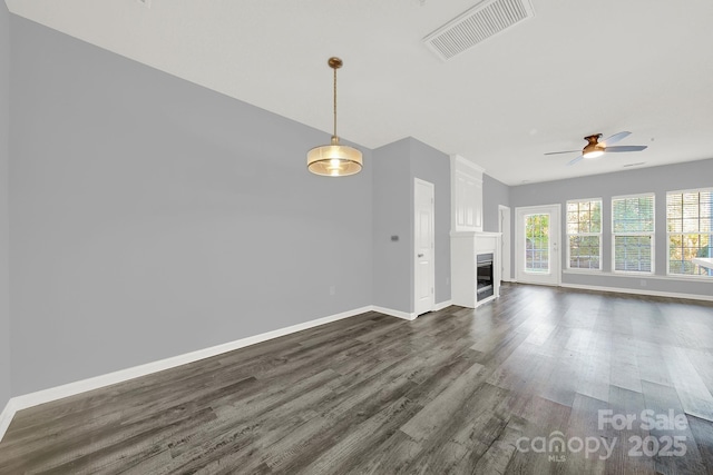 unfurnished living room featuring dark hardwood / wood-style flooring and ceiling fan