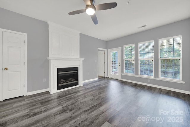 unfurnished living room featuring dark hardwood / wood-style flooring and ceiling fan