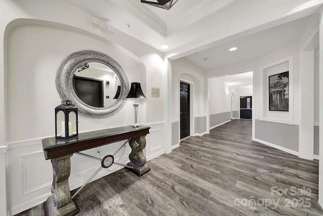 hallway featuring crown molding, a raised ceiling, and hardwood / wood-style floors