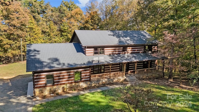 log cabin featuring a front yard and covered porch