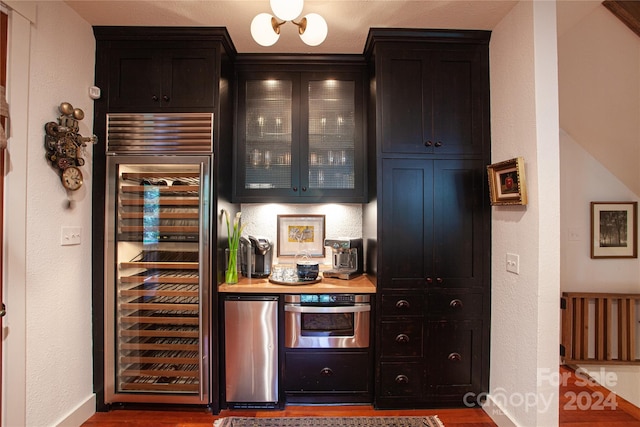 bar with wood-type flooring, wine cooler, stainless steel appliances, and butcher block counters