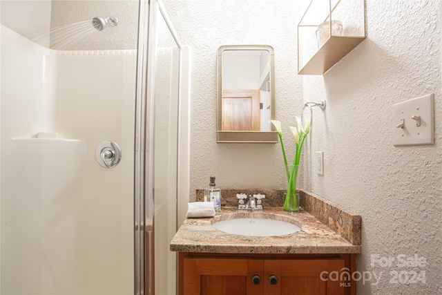 bathroom with walk in shower and vanity