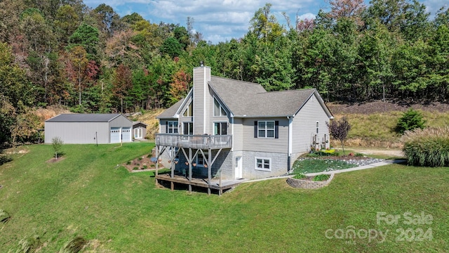 back of property featuring an outdoor structure, a wooden deck, and a lawn