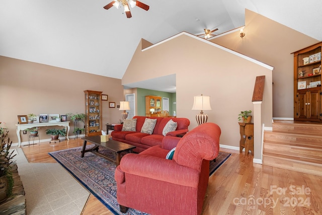 living room with ceiling fan, light hardwood / wood-style flooring, and high vaulted ceiling