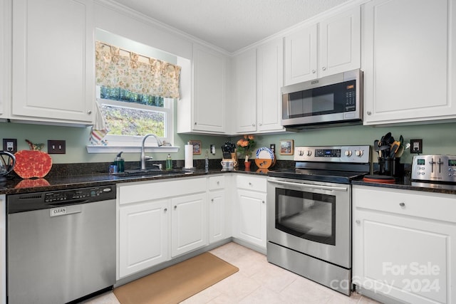 kitchen featuring a textured ceiling, sink, white cabinets, stainless steel appliances, and crown molding